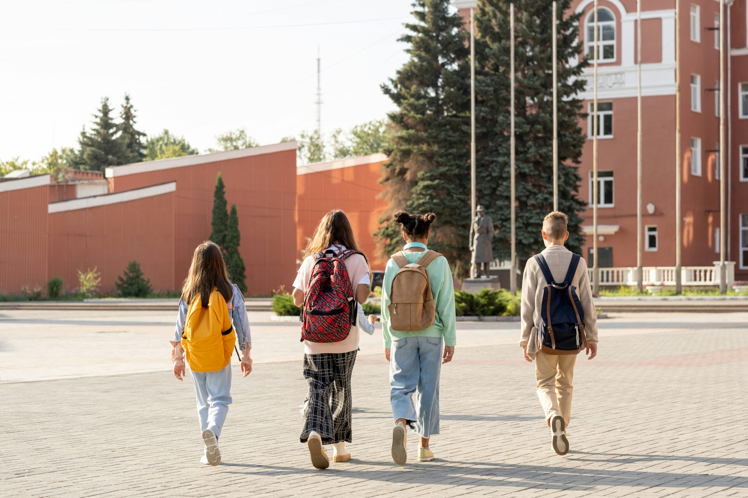 Neighborhood kids walking together with backpacks during the back-to-school season near a Covey Homes rental home community